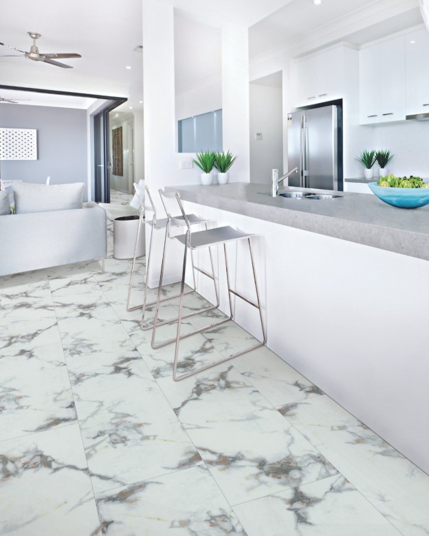 A kitchen with white and grey marble flooring with large patterned tiles